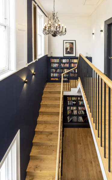 Elegant staircase - Double height stairwell and landing with black chandelier and oak treads.